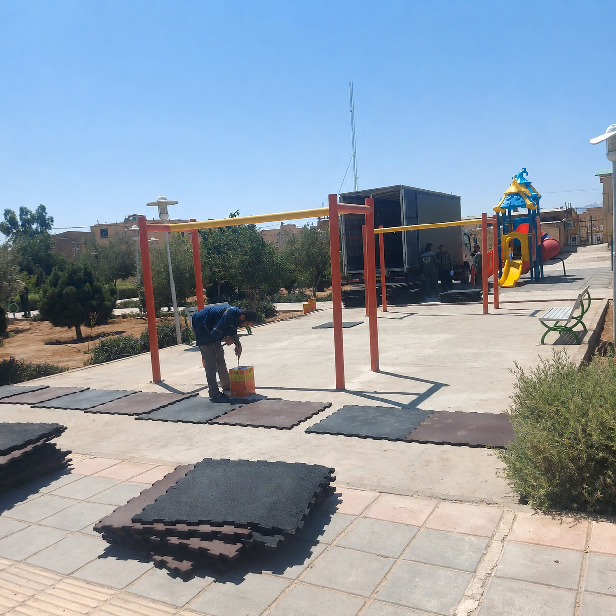 Interlocking rubber granule tiles being installed in the park